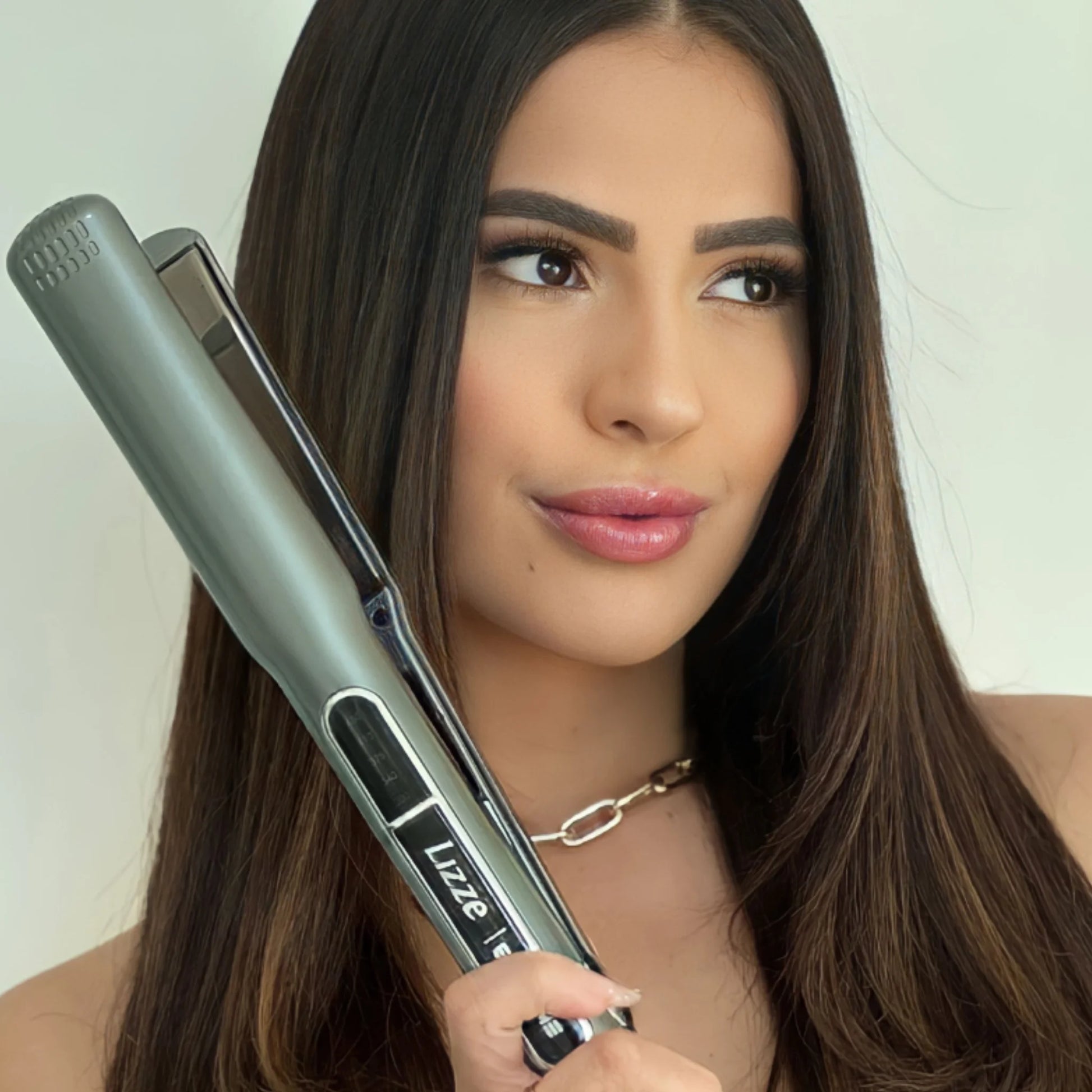 Modelo con cabello liso y brillante usando la plancha Lizze Extreme Titanio
